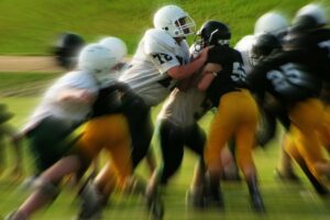 football players tackling on a field representing prioritizing and tackling tasks