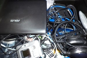 junk drawer full of electronics and spaghetti cords