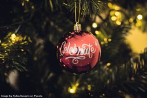 red ball hanging from a spruce tree representing declutter your home for the holidays