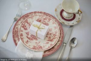 beautiful dishes with a red pattern and high quality silverware set at a table as an example of a life collection of dishes