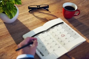 man writing in planner to stop being disorganized