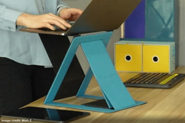 person working on a laptop supported by a foldable stand