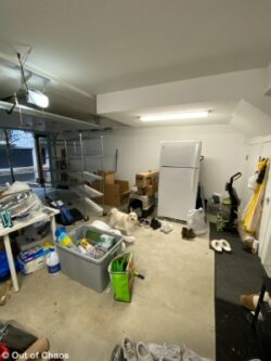 looking at the left hand side of an untidy garage with clutter on the floor and refrigerator in the middle of the wall