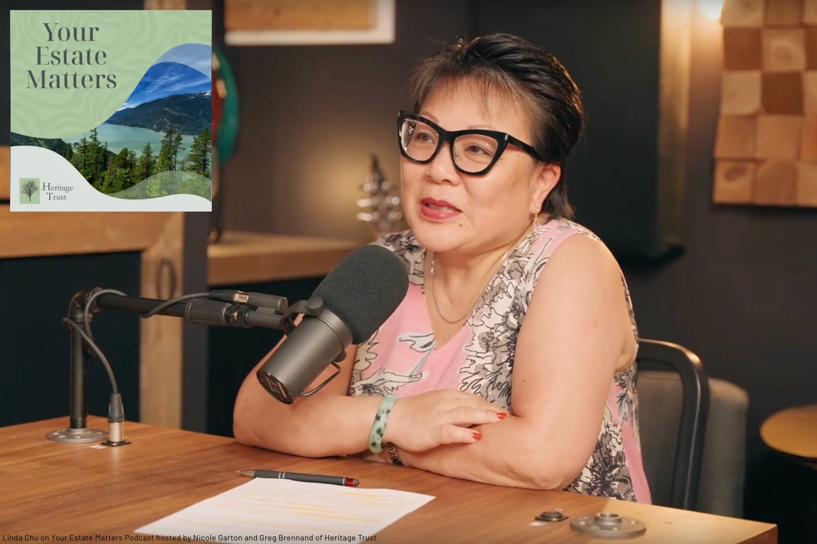 Linda Chu at a desk behind a microphone as a guest on the Your Estate Matters podcast by Heritage Trust discussing what to do with inherited clutter